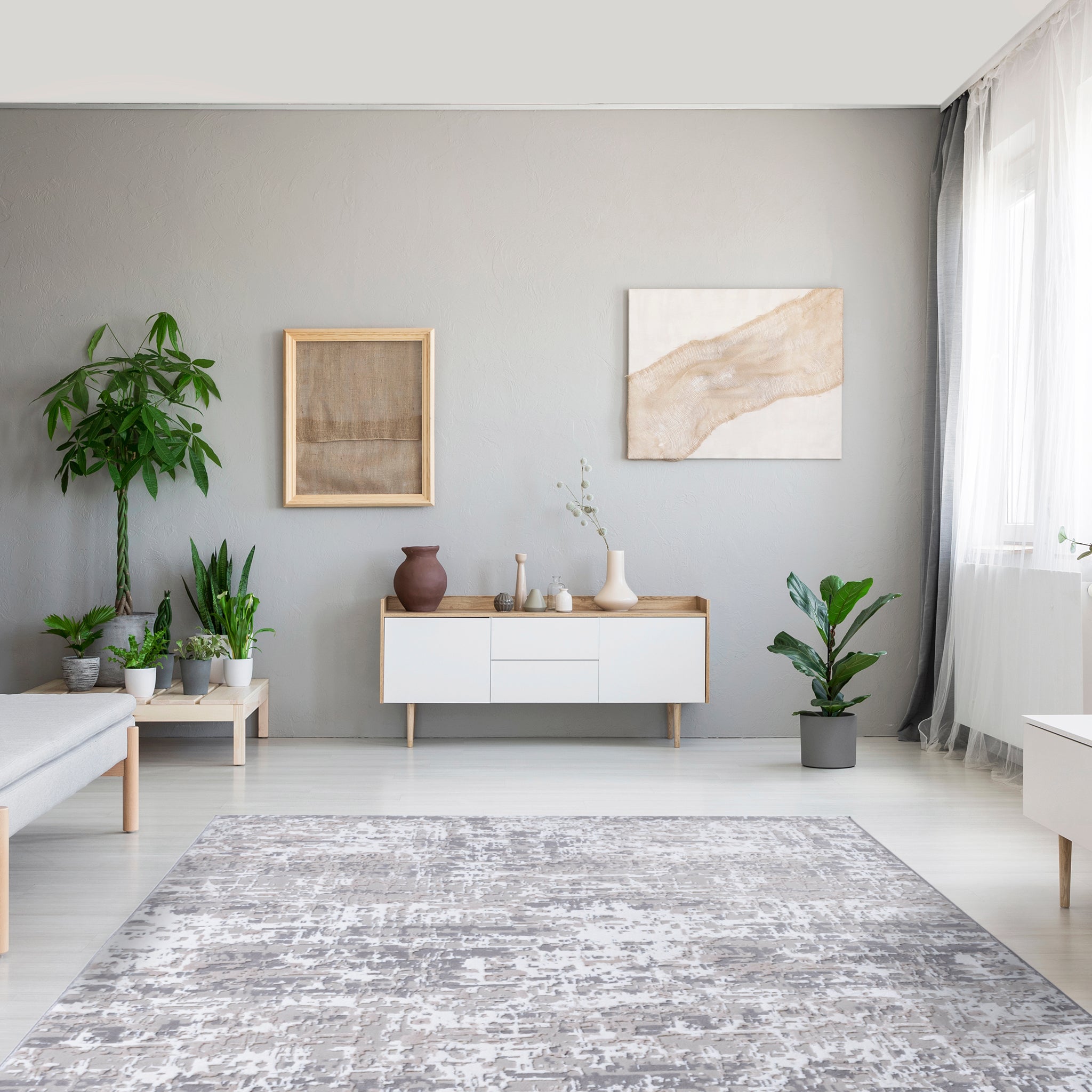 Bright living room interior with grey sofa, white furniture, grey area rug