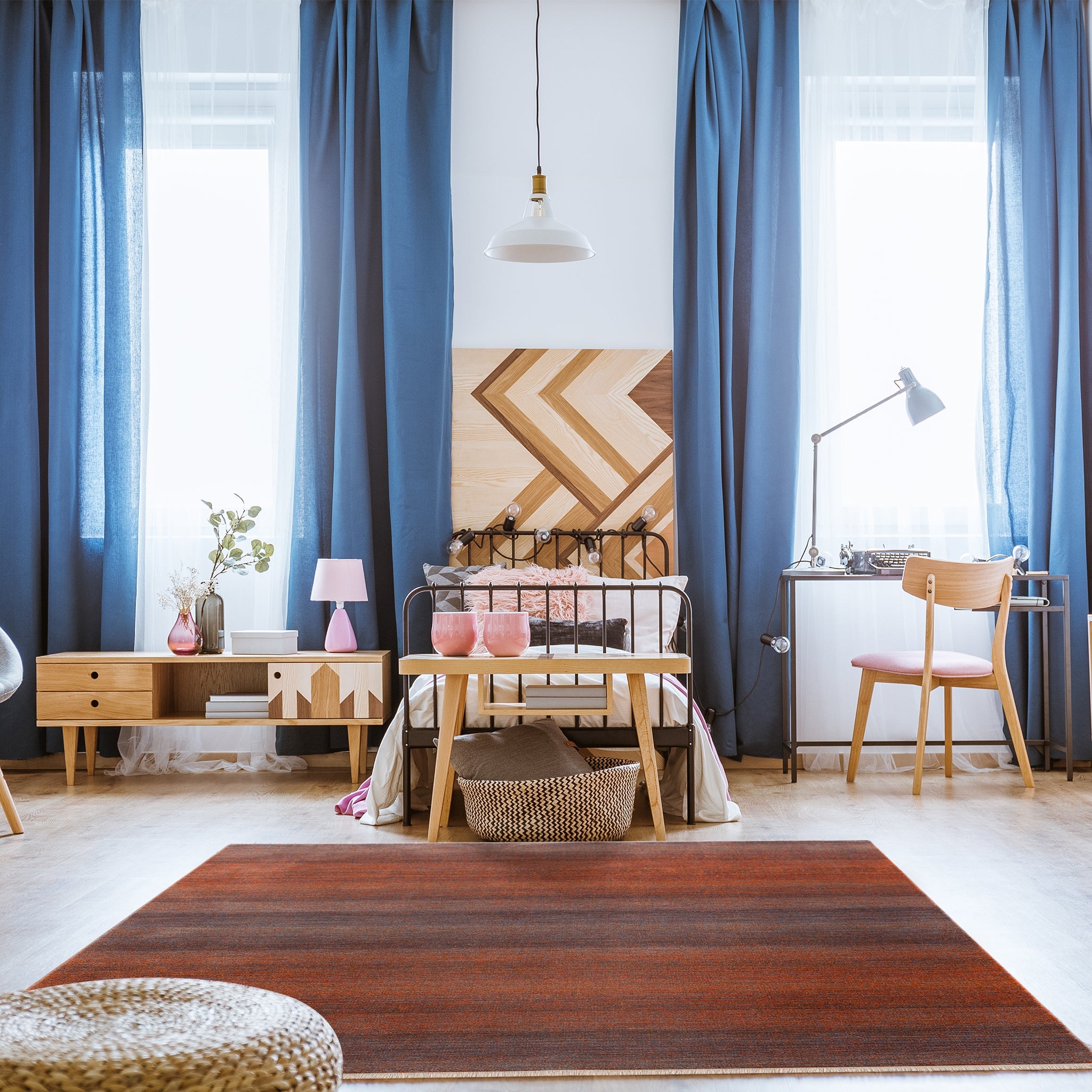 Mystic Orange Rug in bright modern teen bedroom with long blue curtains, metal bed frame, desk, wooden chair and accent table